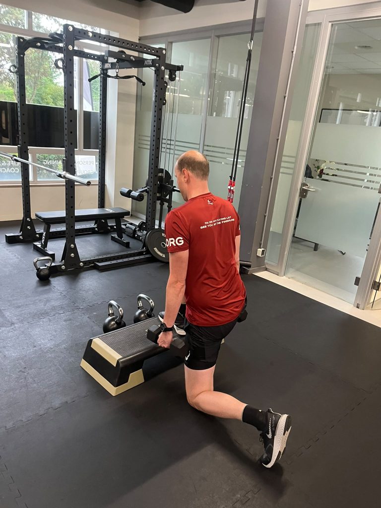 Lid van BOOSTClubs De Meern traint een lunge met dumbbells
